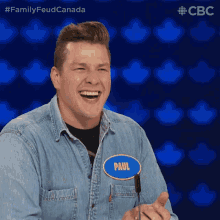 a man in a denim shirt has a name tag that says paul
