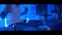 a man playing drums with a blue background