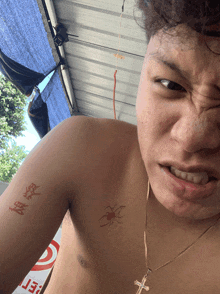 a shirtless man has a tattoo of a spider on his chest