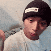 a man wearing a black beanie has a white patch on it that says ' yours '
