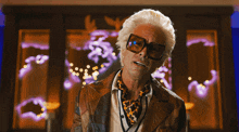 a man wearing sunglasses and a leopard print scarf says " just ask "
