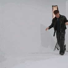 a man in a black jacket and black pants is dancing