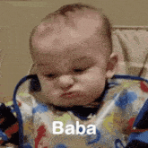 a baby wearing a bib is making a funny face and the word baba is visible