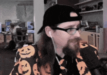 a man with long hair and a beard wearing a black hat