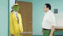 a man in a yellow suit is standing next to a man in a white shirt and the man in the yellow suit says somebody stop me