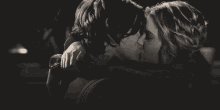 a black and white photo of a couple kissing