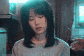 a woman with her eyes closed is wearing a gray shirt