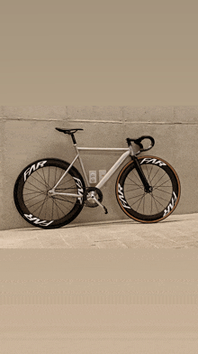 a bicycle is parked in front of a wall that says far