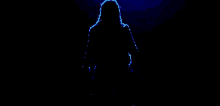 a silhouette of a man holding a knife in a dark room