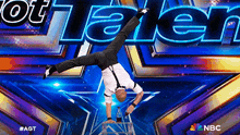 a man is doing a handstand on a ladder in front of a sign that says got talent