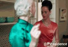 a woman in a red dress is giving a middle finger to another woman