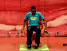 a man in a blue shirt is sitting on a chair