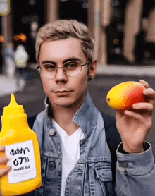 a man is holding a mango and a bottle of mustard