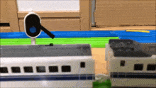 a toy train is sitting on top of a wooden table next to a stop sign .