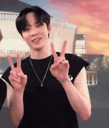 a man wearing a black shirt and a necklace is giving the peace sign