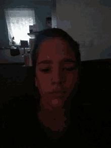 a person 's face is visible in a dark room
