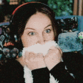 a woman wearing headphones is holding a stuffed animal in front of her mouth