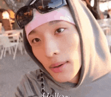 a close up of a person wearing sunglasses and a pink headband .