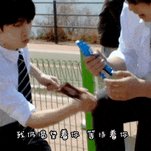 a man in a white shirt and tie is holding a pen with the number 8 on it while another man holds a piece of paper