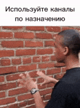 a man standing in front of a brick wall with the words " используйте каналы по назначению " on the bottom