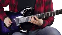 a man wearing a plaid shirt is playing a purple electric guitar