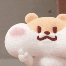 a stuffed animal with an angry face is being held in someone 's hand .
