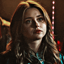 a close up of a woman 's face with a red light in the background