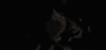 a person is walking through a dark cave with a light coming out of it .