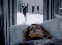 a woman is laying in a hospital bed with a neck brace on her head .