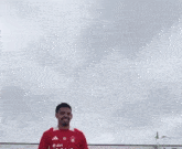 a man in a red e-on nex jersey is smiling