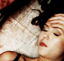 a woman with her hand on her forehead is laying on a bed next to a man