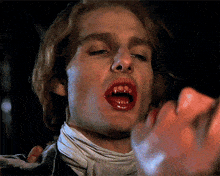 a close up of a vampire with blood on his mouth