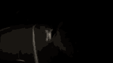 a blurry picture of a person hanging from a pole in the dark .