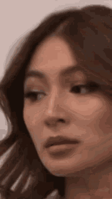 a close up of a woman 's face with her eyes closed and her hair blowing in the wind .