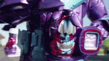 a close up of a purple robot with a red and blue item in its mouth