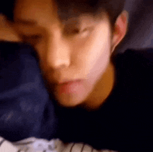 a close up of a man laying in bed with his eyes closed and his mouth open .