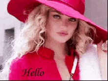 a woman wearing a pink hat and a red jacket with the word hello on her chest