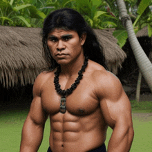 a shirtless man with long hair is wearing a necklace and standing in front of a thatched hut .