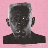 a black man with his tongue out is making a funny face on a pink background .