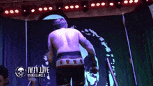 a man stands in front of a purple curtain that says iwtv live on it