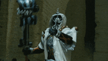 a person in a white costume is holding a gun