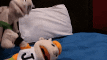 a stuffed animal with the letter j on its shirt is laying on a bed