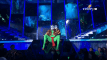 a group of people watching a performance on a television screen that says colors hd