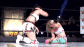 two women are wrestling in a ring with a sign that says tk on it