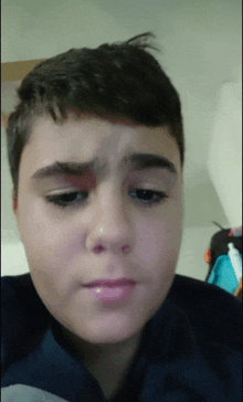 a young boy with a black spot on his forehead looks at the camera