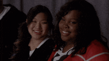 two women are smiling and one is wearing a black jacket