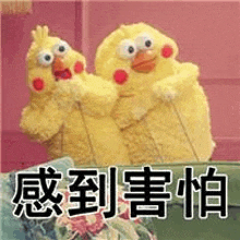 two stuffed chickens are sitting next to each other on a couch in a room .