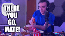a man wearing headphones is sitting at a table eating fried chicken with the words there you go mate written above him
