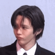 a young man in a suit and tie is making a face .