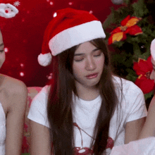 a woman wearing a santa hat and a white t-shirt